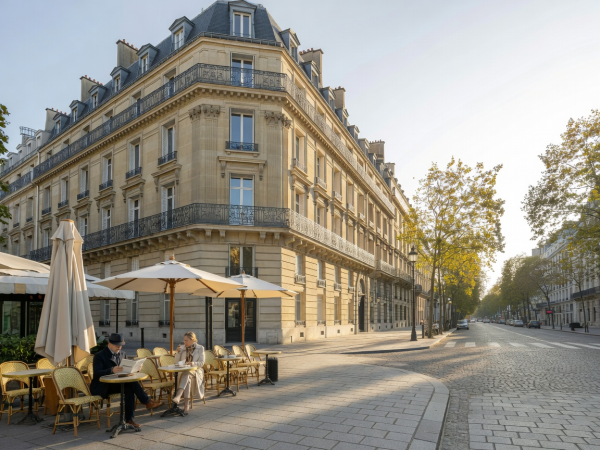 Elegant Parisian Haussmann building and boulevard terrace viewed in morning light